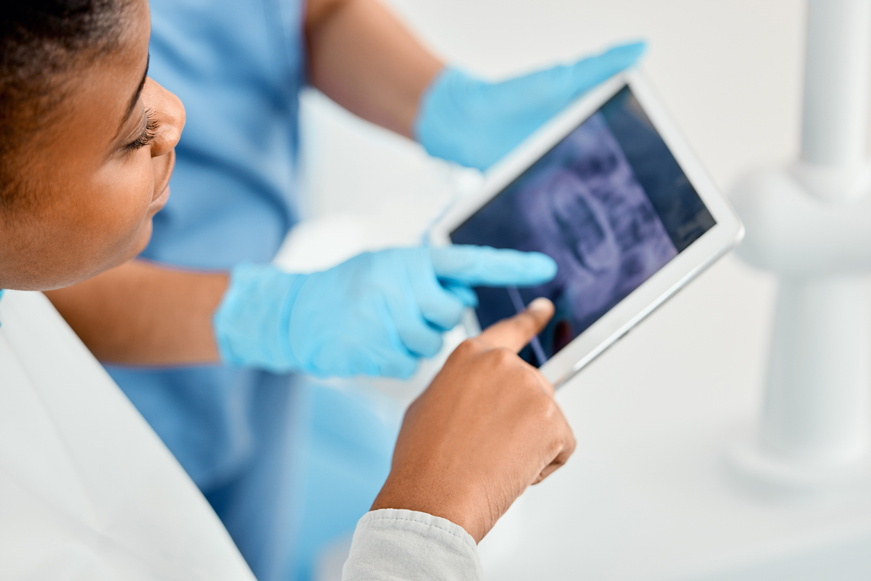 Shot Of A Young Woman Looking Over Her Dental X Rays With Her Doctor Using A Tablet